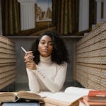 Elegant young woman in library with books. Ideal for educational themes.